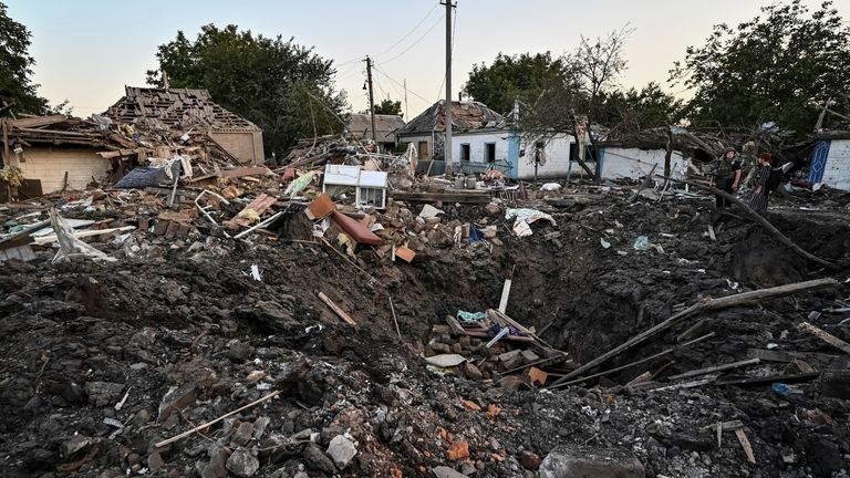 People stand next to a residential house destroyed by a Russian military strike, as Russia&#39;s attack on Ukraine continues, in Chaplyne, Dnipropetrovsk region, Ukraine August 24, 2022. REUTERS/Dmytro Smolienko
