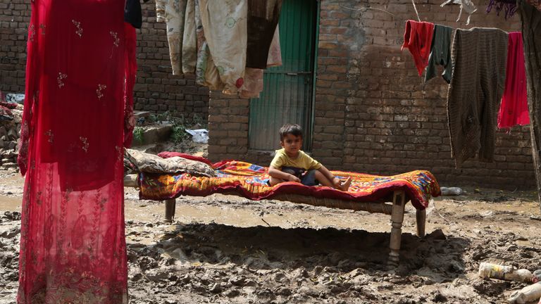 A boy lies on a cot near his flood-hit home, in Charsadda, Pakistan, Wednesday, Aug. 31, 2022. Officials in Pakistan raised concerns Wednesday over the spread of waterborne diseases among thousands of flood victims as flood waters from powerful monsoon rains began to recede in many parts of the country. (AP Photo/Mohammad Sajjad)