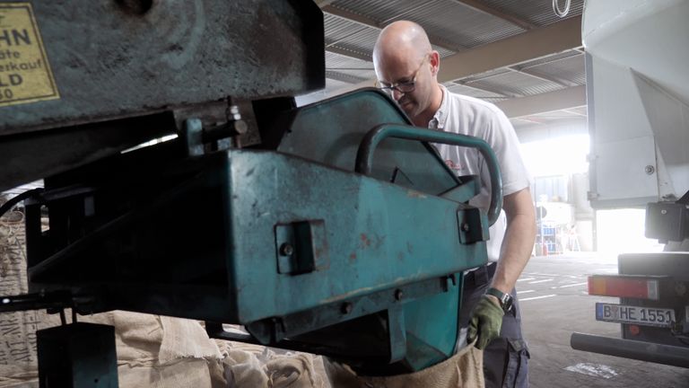 coal seller Frithjof Engelke, junior manager at “Hans Engelke Energie” in Berlin, bagging coal in his store