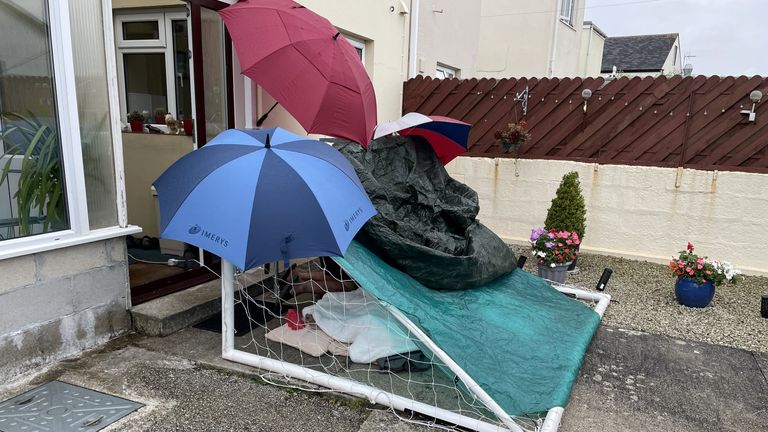 The family of an 87-year-old who fell at home were forced to build a shelter for him out of a football goal - as he waited 15 hours in the rain through the night for an ambulance.
