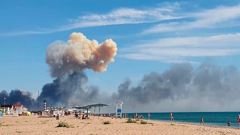 Rising smoke can be seen from a beach near the air base