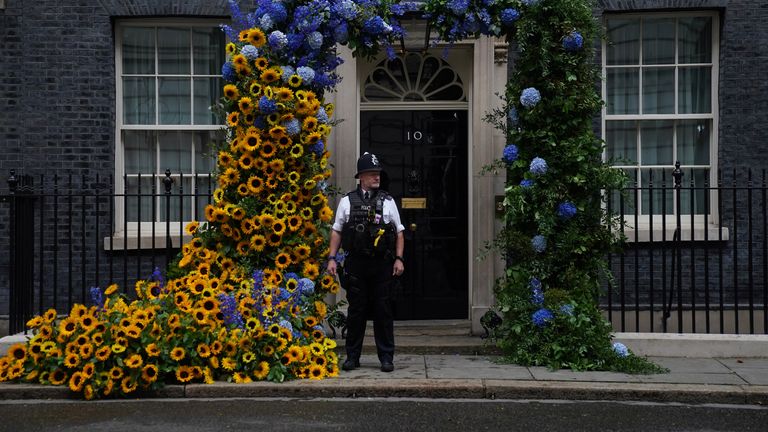A police officer stands beside a floral arch of sunflowers at the door to 10 Downing Street, London, to show the UK&#39;s support for Ukraine, who celebrate their independence day on Wednesday. Picture date: Tuesday August 23, 2022.