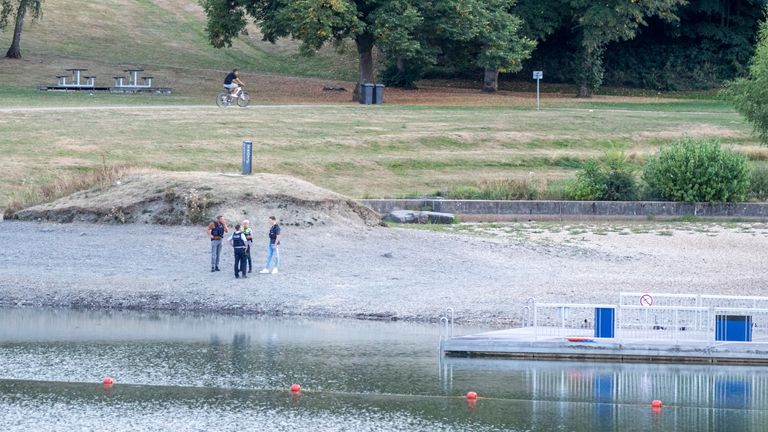 August 25, 2022, North Rhine-Westphalia, Simmerath: Police officers stand on the shores of Lake Eiserbach in central Rursee.  Two children died after an accident while swimming in a swimming pool near Aachen.  This was informed by a police spokeswoman on August 26. According to the police, the boys aged 7 and 9 were reported missing at the Eiserbachsee on Thursday evening and were later found underwater one day. bit later PIC:AP