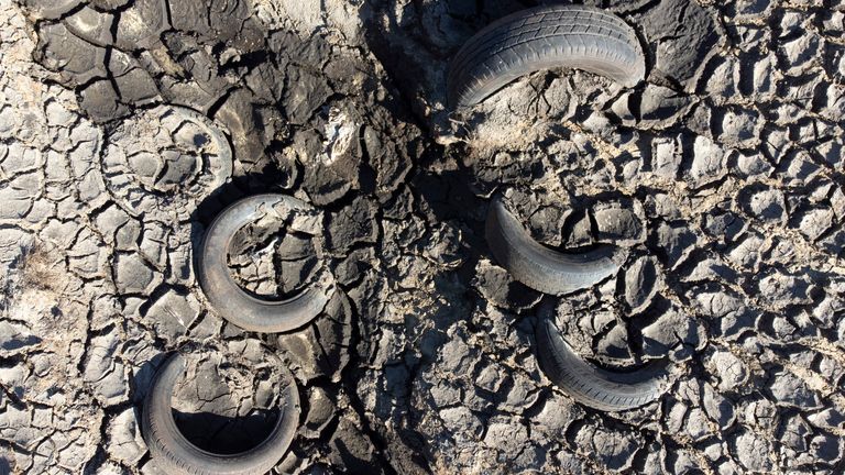 Car tyres are seen in an area exposed by low water levels at Baitings Reservoir in Yorkshire as record high temperatures are seen in the UK, Ripponden, England, Friday, Aug. 12, 2022. Low water levels at the reservoir have revealed amongst other things the remains of the ancient road flooded to build the reservoir in the 1950s. (AP Photo/Jon Super)