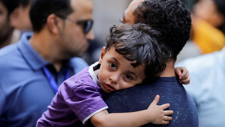 A child looks on as people gather near the scene where a deadly fire broke out at the Abu Sifin church in Giza, Egypt, August 14, 2022. REUTERS/Mohamed Abd El Ghany
