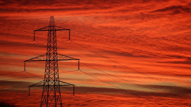 The sun rises behind an electricity pylon in Manchester, Britain, January 18, 2022. REUTERS/Phil Noble
