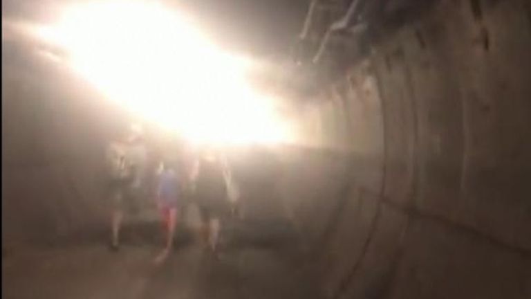 Des passagers marchent le long du tunnel de service de l'Eurotunnel après la panne d'un train