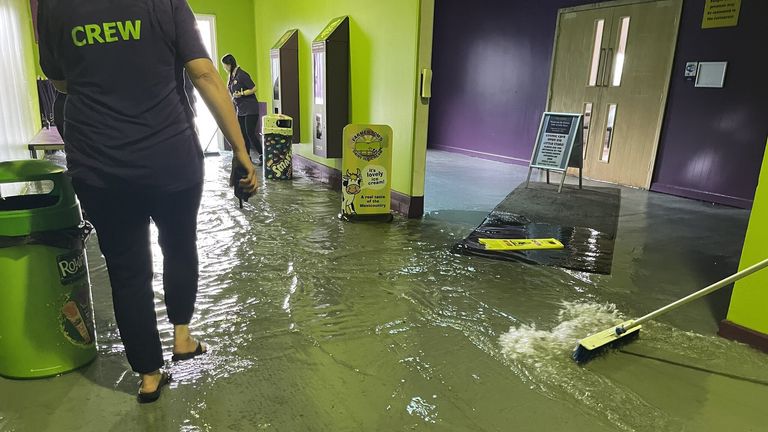 Members of staff at The Milky Way in Devon clear out floodwater inside the premises