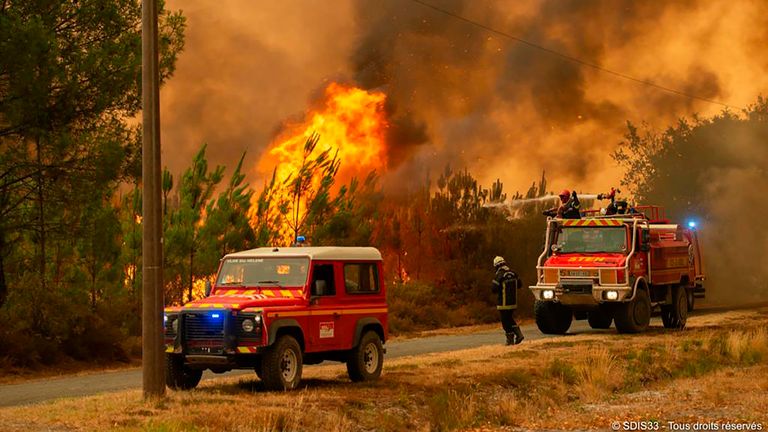 This photo provided by the fire brigade of the Gironde region SDIS 33, (Departmental fire and rescue service 33) shows firefighters tackling a blaze near Hostens, south of Bordeaux, southwestern France, Wednesday, Aug. 10, 2022. (SDIS 33 via AP)