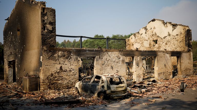 A view of a house and a car destroyed by fire in Belin-Beliet, as wildfires continue to spread in the Gironde region of southwestern France, August 11, 2022. REUTERS/Stephane Mahe
