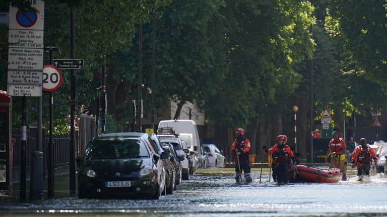 Anëtarët e Brigadës së Zjarrfikësve të Londrës ndihmojnë në transportimin e banorëve lokalë përgjatë rrugës Hornsey, Holloway, në veri të Londrës, pas një shpërthimi të ujit prej 36 inç, duke shkaktuar përmbytje deri në katër metra të thellë. Data e fotografisë: e hënë 8 gusht 2022. 