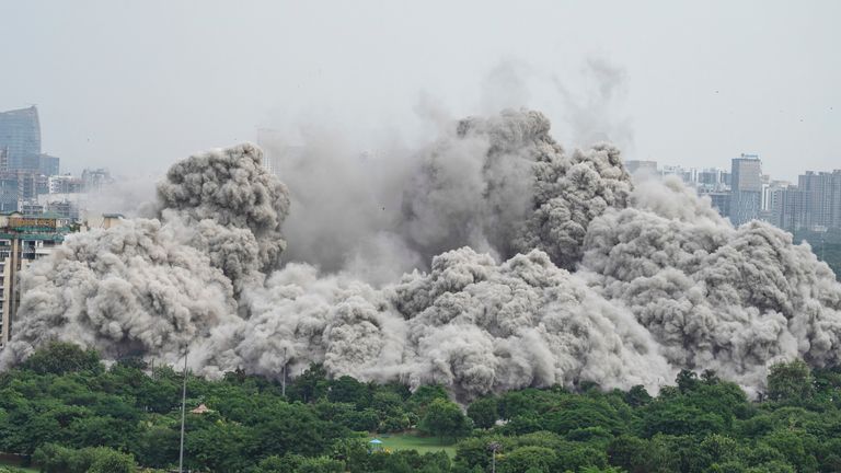 Cloud of dust rises as twin high-rise apartment towers are razed to ground. Pic: AP