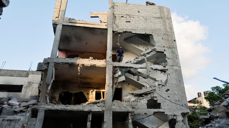 A Palestinian man stands inside a damaged building as people gather at the scene where senior commander of Islamic Jihad militant group Khaled Mansour was killed in Israeli strikes, in Rafah in the southern Gaza Strip, August 7, 2022. REUTERS/Ibraheem Abu Mustafa