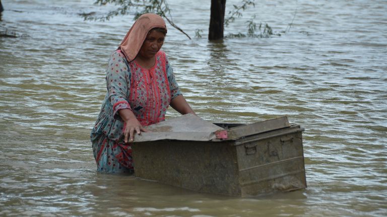 A woman uses a trunk to salvage usable items from her flood-hit home in Jaffarabad, a district of Pakistan&#39;s southwestern Baluchistan province, Thursday, Aug. 25, 2022. Pakistan&#39;s government in an overnight appeal sought relief assistance from the international community for flood-affected people in this impoverished Islamic nation, as the exceptionally heavier monsoon rain in recent decades continued lashing various parts of the country. (AP Photo/Zahid Hussain)