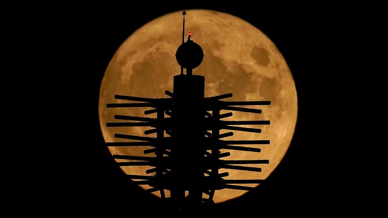 A supermoon rises beyond artwork on top of a convention center Thursday, Aug. 11, 2022, in downtown Kansas City, Mo. (AP Photo/Charlie Riedel)
PIC:AP