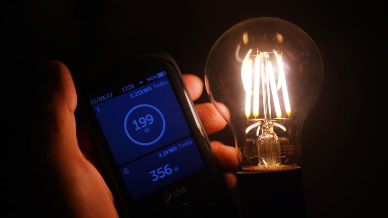 A handheld SSE smart meter for household energy usage is held next to an energy-efficient LED light bulb.  Families across Great Britain will find out on Friday how tough energy bills will be this winter but they may have to wait to discover what the Government will do to help Picture date: Thursday August 25, 2022.