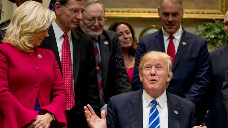 From left, Rep. Liz Cheney, R-Wyo., Sen. John Barrasso, R-Wyo., Rep. Don Young, R-Alaska, Lolita Zinke, her husband, Interior Secretary Ryan Zinke, Vice President Mike Pence, Sen. Ron Johnson, R-Wis., and Rep. Virginia Foxx, R-N.C., listens as President Donald Trump speaks while signing various bills in the Roosevelt Room of the White House in Washington, Monday, March 27, 2017. (AP Photo/Andrew Harnik)