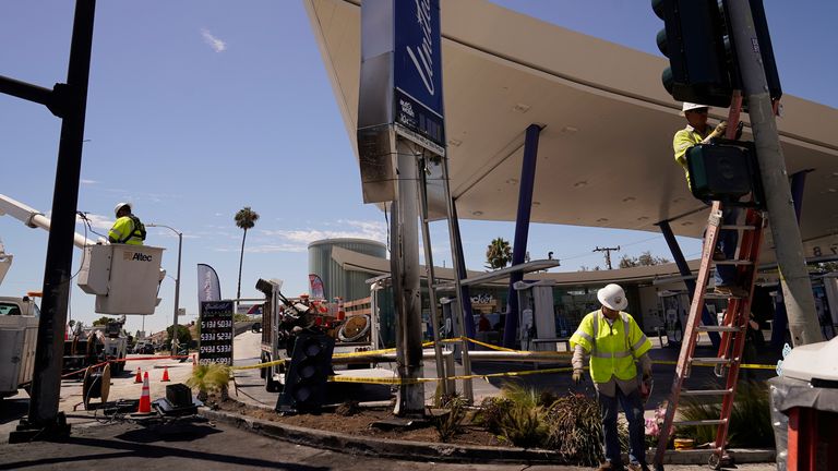 Technicians replace burnt traffic lights and signs following the crash in Windsor Hills, Los Angeles. Pic: AP