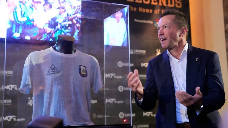 Former German soccer player Lothar Matthaus stands next to the show case featuring the shirt worn by Diego Armando Maradona in the final of the 1986 World Cup in Mexico, as it is unveiled, during an event at the Argentine Embassy in Madrid, Spain, Thursday Aug. 25, 2022. The shirt was given to Matthaus, after he exchanged shirts with Maradona at the end of the final match. Matthaus has donated the shirt to the Legends football museum in Madrid. (AP Photo/Paul White)