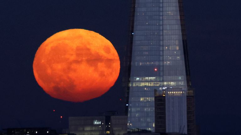 The full moon rises near the Shard skyscraper, London, Britain, August 11, 2022. REUTERS/Peter Cziborra
