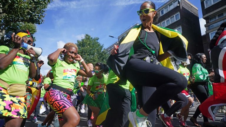 People from the Emancipated Run Crew who are running the carnival parade all in green to remember the 72 people that died in the Grenfell fire