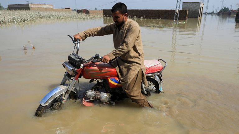 A man rides a motorcycle through flood water, following rains and floods during the monsoon season, in Nowshera, Pakistan August 31, 2022. REUTERS/Fayaz Aziz

