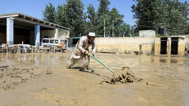 A man clears the mud from the ground following rains and floods during the monsoon season in Charsadda, Pakistan August 28, 2022. REUTERS/Fayaz AzizAziz