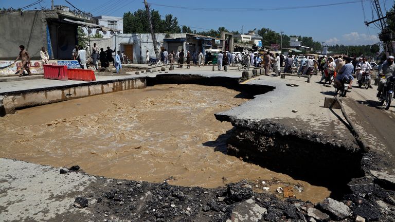 A road is damaged from flooding on the outskirts of Peshawar, Pakistan, Sunday, Aug. 28, 2022. Officials in Pakistan say deaths from widespread flooding have topped 1,000 since mid-June. Flash flooding from the heavy rains has washed away villages and crops as soldiers and rescue workers evacuated stranded residents to the safety of relief camps and provided food to thousands of displaced Pakistanis. (AP Photo/Mohammad Sajjad)