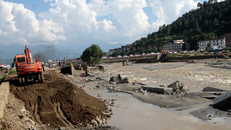 Local authorities use heavy machinery to rebuild a damaged road after a flood-affected area, in Swat valley, Pakistan, Sunday, Aug. 28, 2022. International aid for flood victims have started arriving in Pakistan, as military helicopters, troops and rescuers resumed operations early Monday to evacuate marooned people and deliver much-needed food after the deluge killed over 1,000 since mid-June. (AP Photo/Naveed Ali)