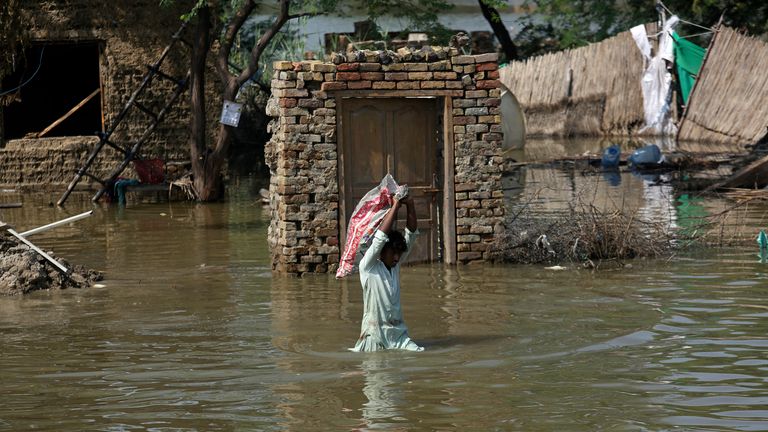 A man wading through flood waters in Sindh province, Pakistan.  Photo: AP