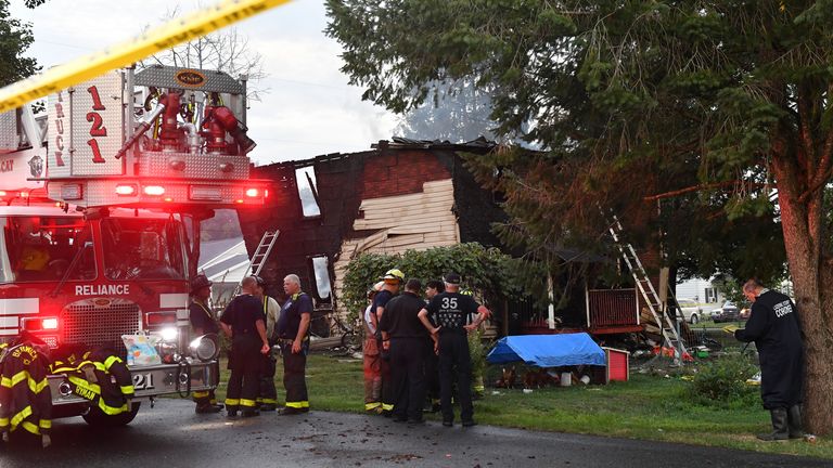 Firefighters gather next to a house after a deadly morning fire at 733 First Street in Nescopeck, Pennsylvania on Friday, August 5, 2022. The fire was reported at around 2:30 am.  The cause of the fire is still under investigation.  (Jimmy May / Bloomsburg Press Enterprise via AP)