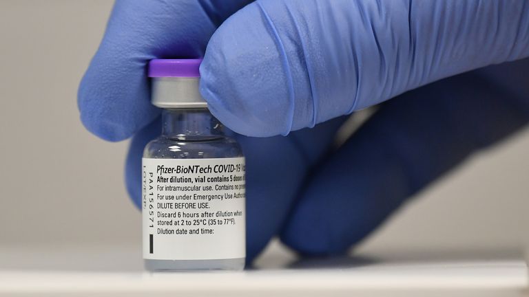 A member of staff poses with a phial of Pfizer-BioNTech Covid-19 vaccine at a vaccination centre in Cardiff on the first day of the largest immunisation programme in the UK&#39;s history. Care home workers, NHS staff and people aged 80 and over began receiving the jab this morning.