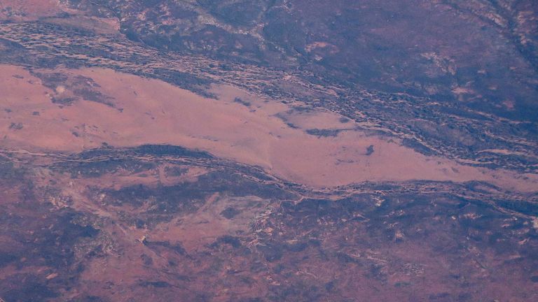 A road leads to an open-cut mine in the area known as the Pilbara region located in the north-west of Western Australia
