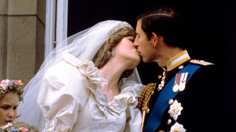 The newly married Prince and Princess of Wales (formerly Lady Diana Spencer) kiss on the balcony of Buckingham Palace after their wedding ceremony at St. Paul&#39;s cathedral.