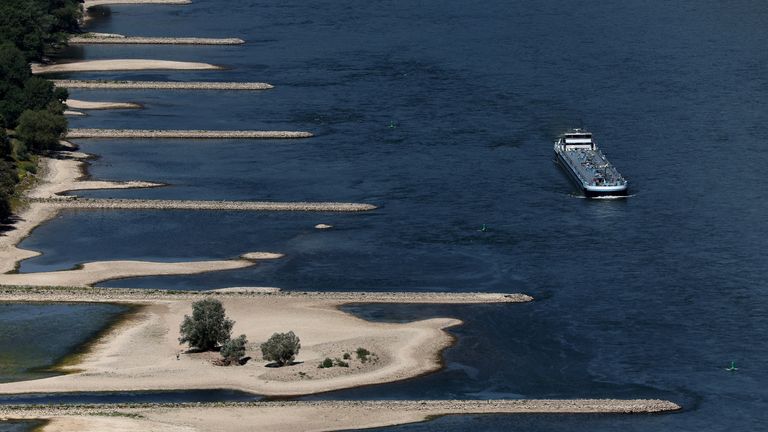 A transport vessel cruises past the partially dried riverbed of the Rhine river in Bingen, Germany, August 9, 2022. REUTERS/Wolfgang Rattay
