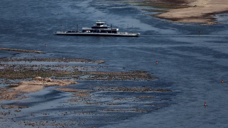 A ferry cruises past the partially dried riverbed of the Rhine river in Bingen, Germany, August 9, 2022. REUTERS/Wolfgang Rattay
