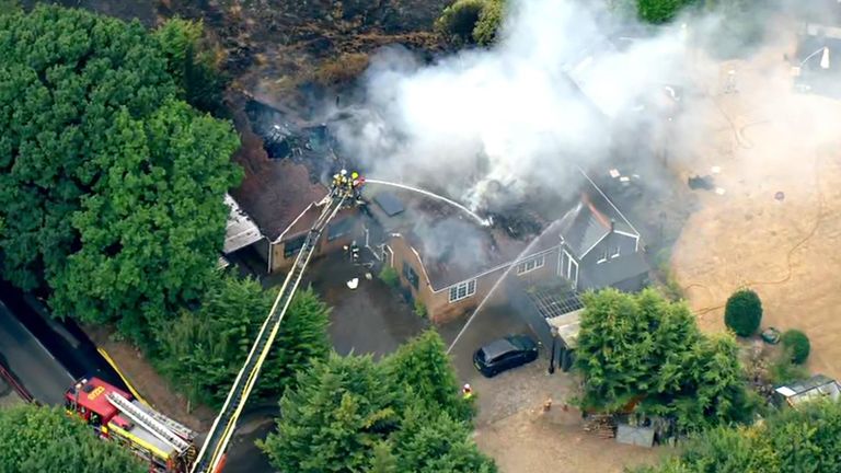 Grass fire spreads to properties in Runnymede, Surrey
