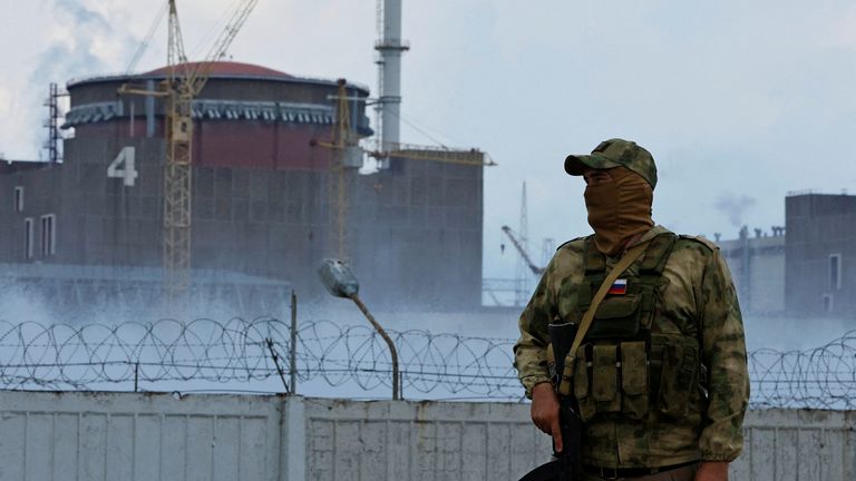A soldier with a Russian flag on his uniform stands guard near the Zaporizhzhia nuclear power plant on August 4