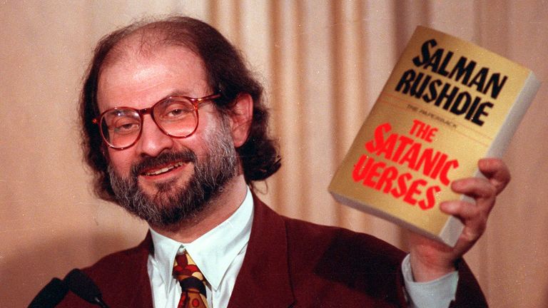 Novelist Salman Rushdie holds a paperback copy of his controversial novel. "satanic verses" March 4, 1992. Photo: AP