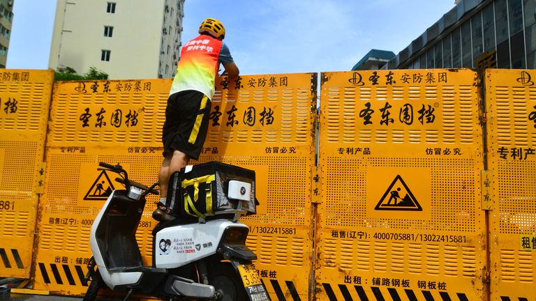 Un coursier tente de faire une livraison sur une barricade de verrouillage à Sanya