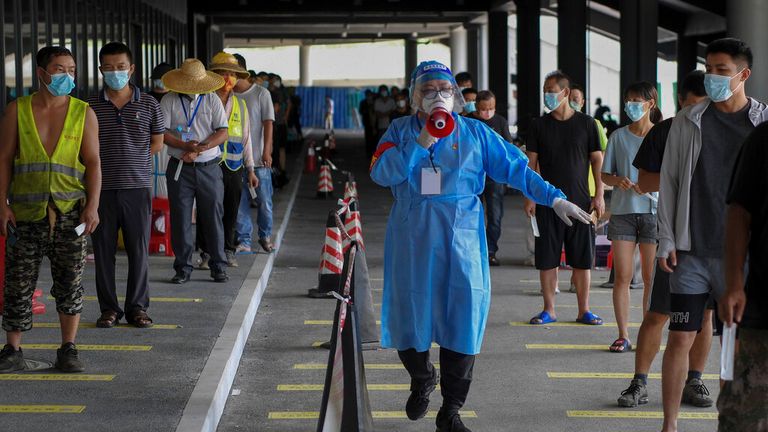 A man enforces social distancing at a testing site in Sanya, Hainan Province. Pic: AP