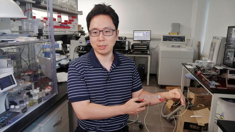 Kore İleri Bilim ve Teknoloji Enstitüsü'nde (KAIST) Malzeme Bilimi ve Mühendisliği profesörü olan Steve Park, 26 Temmuz'da Daejeon, Güney Kore'de bir elektrokardiyogram (EKG) izleme sistemi ile bağlantılı kolunda bir elektronik dövme (e-dövme) sergiliyor, 2022. REUTERS/Minwoo Parkı