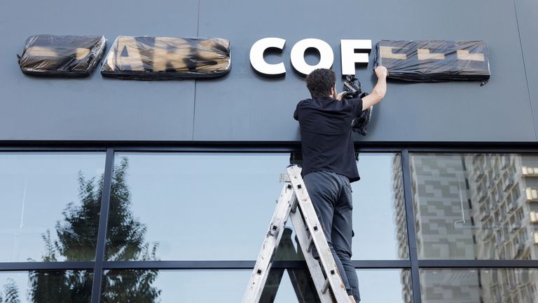 A staff removes cover from a sign of the new coffee shop "Stars Coffee", which opens following Starbucks Corp company&#39;s exit from the Russian market, in Moscow, Russia August 18, 2022. REUTERS/Maxim Shemetov
