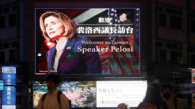 People walk past a billboard welcoming U.S. House Speaker Nancy Pelosi, in Taipei, Taiwan, Tuesday, Aug 2, 2022. U.S. House Speaker Nancy Pelosi was believed headed for Taiwan on Tuesday on a visit that could significantly escalate tensions with Beijing, which claims the self-ruled island as its own territory. (AP Photo/Chiang Ying-ying)