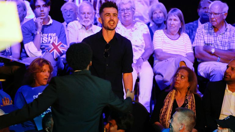 The protesters shouted "shame on you" and "Green New Deal" as they stood holding placards inside the hustings venue