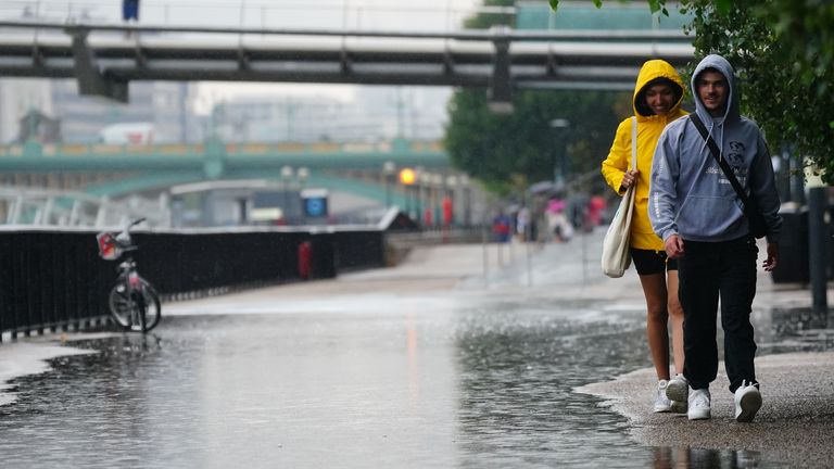 People walking in the rain in London. After weeks of sweltering weather, which has caused drought and left land parched, the Met Office&#39;s yellow thunderstorm warning forecasts torrential rain and thunderstorms that could hit parts England and Wales. Picture date: Wednesday August 17, 2022.