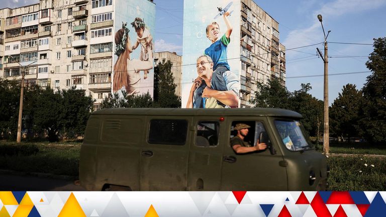 Ukraine servicemen drive past a mural of a family on damaged buildings in Bakhmut, as Russia&#39;s invasion of Ukraine continues, in Donetsk region, Ukraine August 14, 2022. REUTERS/Nacho Doce     TPX IMAGES OF THE DAY     
