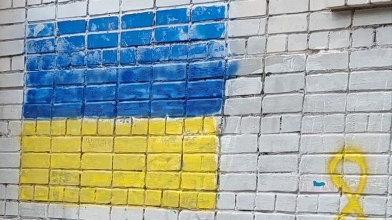 The yellow and blue of Ukraine painted on a wall in occupied Kherson