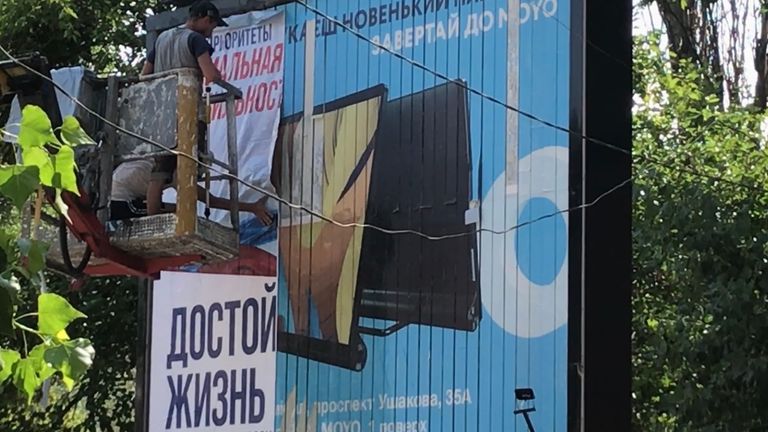 Pro-Russian propaganda being put up on a big billboard. Once it&#39;s up, it will read "with Russia, a decent life" and is directed at pensioners
