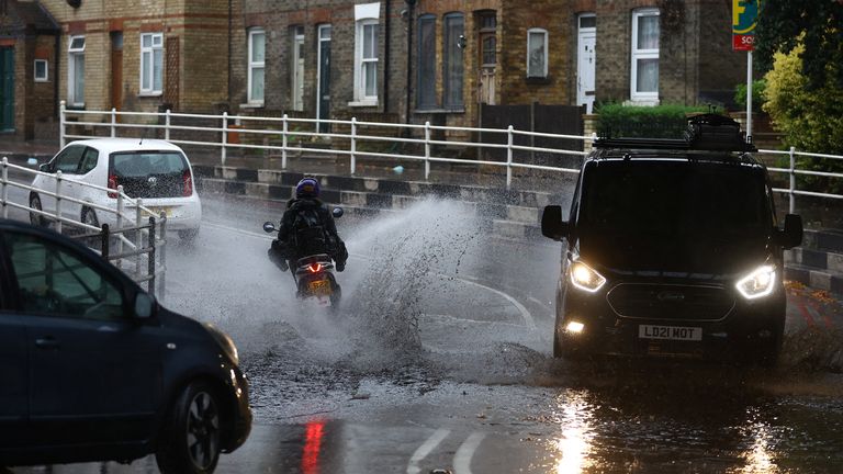 Vehicles drive through a flooded street of a residential area after heavy rain hits London, Britain August 25, 2022. REUTERS/Hannah Mckay
